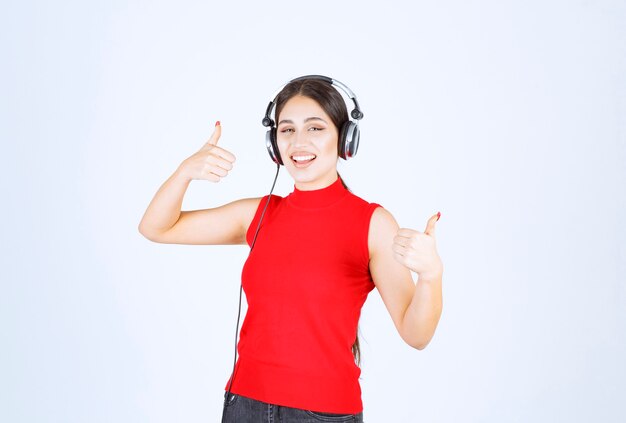 DJ de camisa vermelha, usando fones de ouvido e curtindo a música.