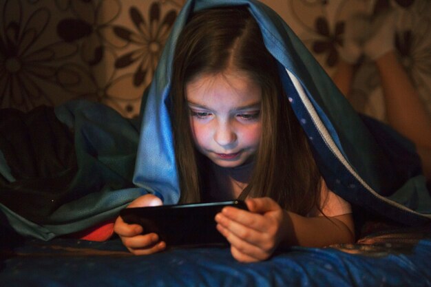 Foto grátis doce menina navegando smartphone na noite