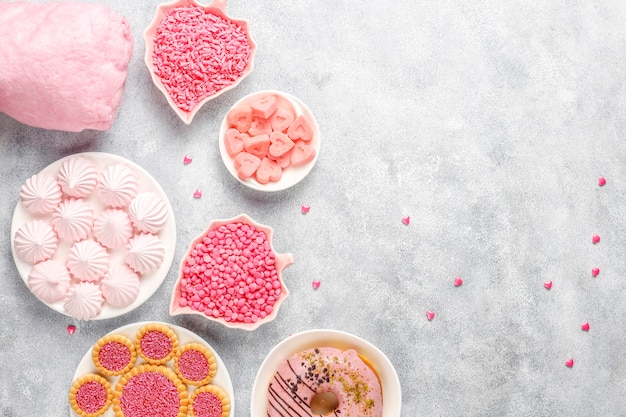 Doces de cor rosa, balas, merengue e açúcar.