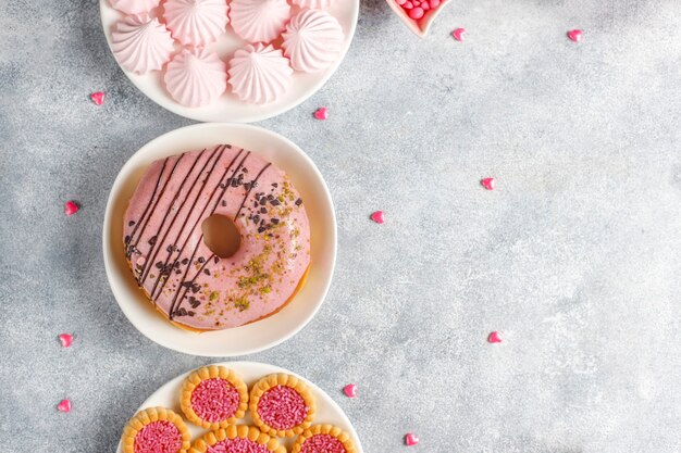 Doces de cor rosa, balas, merengue e açúcar.