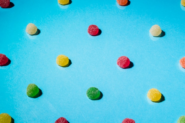 Foto grátis doces de geleia de açúcar circular colorido sobre fundo azul