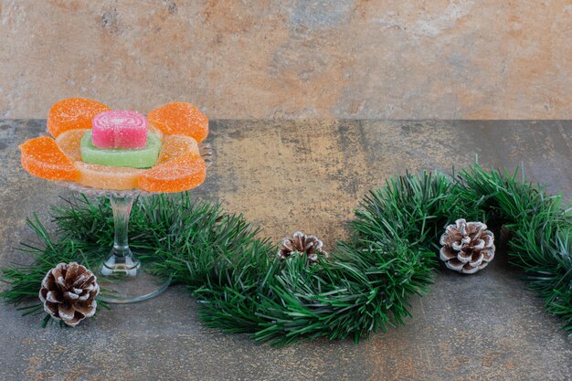 Doces de geleia de frutas açucaradas com pinhas e ramo de árvore de Natal. Foto de alta qualidade