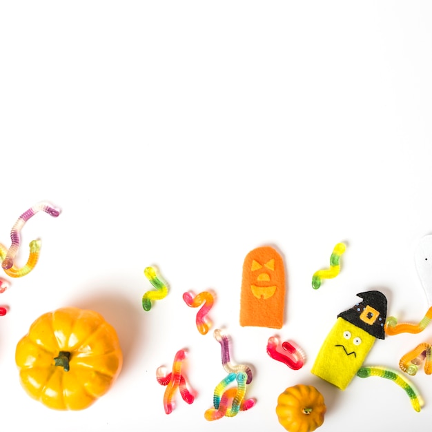 Foto grátis doces de geleia perto de brinquedos e abóboras