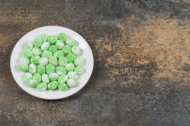 Doces de mentol verde na chapa branca.