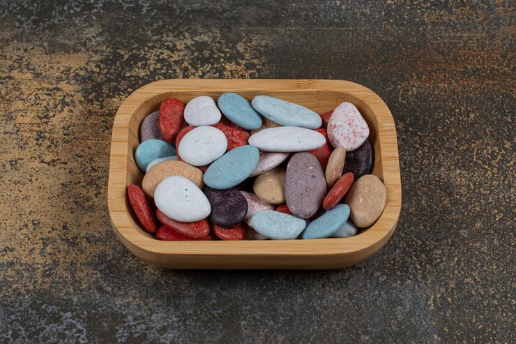 Foto grátis doces de pedra em forma oval na placa de madeira.