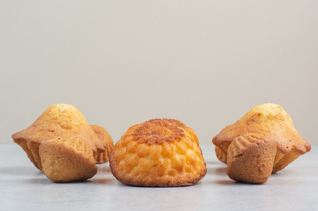 Doces deliciosos bolinhos na mesa branca.