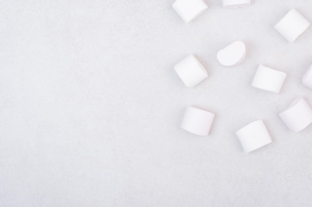 Foto grátis doces marshmallows brancos na mesa branca.