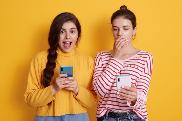 Dois amigos com telefones lendo notícias chocantes na rede social