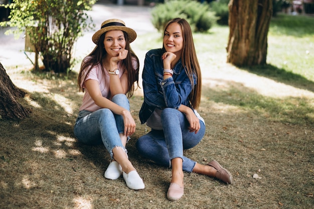 Dois amigos meninas, sentando, parque