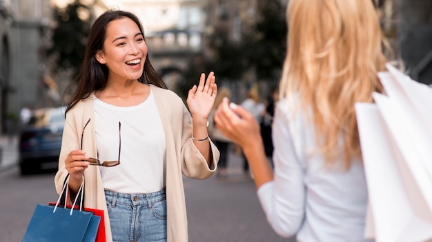 Dois amigos se encontram após uma sessão de compras em promoção