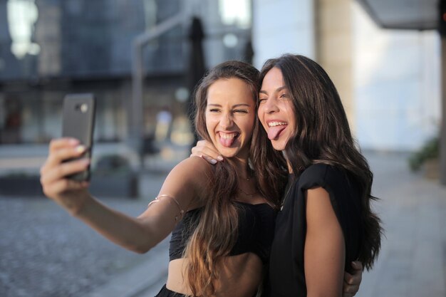 Dois amigos tiram uma selfie com rostos
