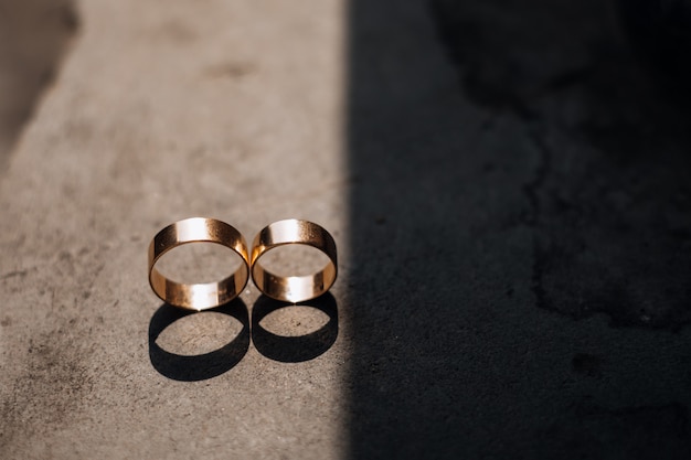 Foto grátis dois anéis de casamento de ouro encontram-se no raio de luz