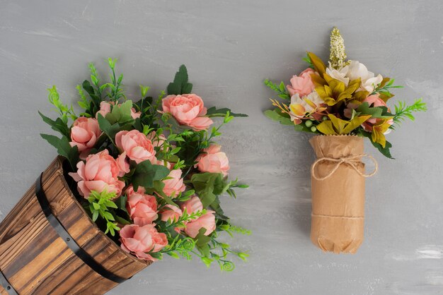 Dois belos buquês de flores na superfície cinza.