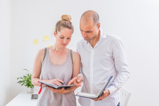 Dois, businesspeople, discutir, cronograma, em, diário, em, local trabalho