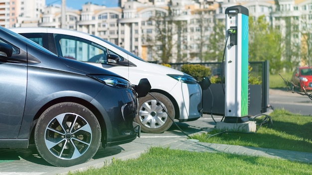 Dois carros elétricos de carregamento na estação de carregamento da cidade