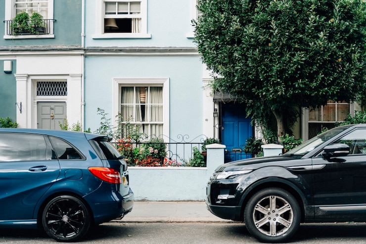 Foto grátis dois carros estacionados na frente da entrada de um apartamento