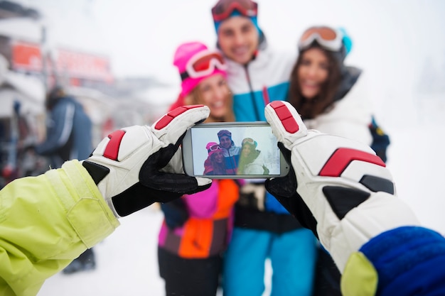 Dois casais se divertindo e praticando snowboard