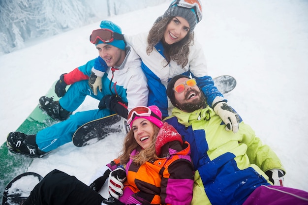 Dois casais se divertindo e praticando snowboard