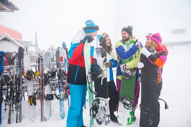 Dois casais se divertindo e praticando snowboard