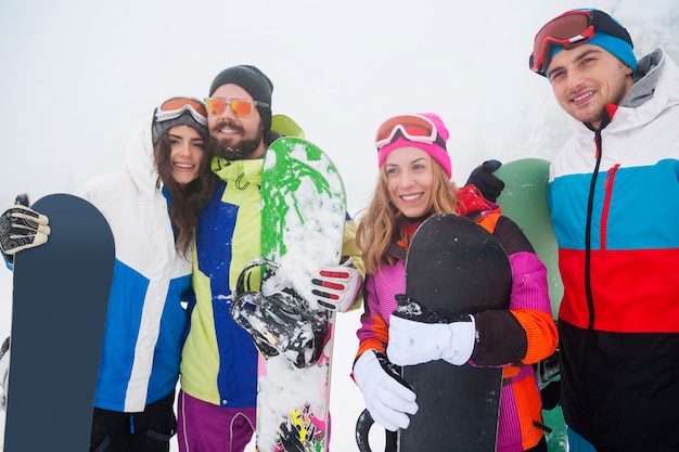 Dois casais se divertindo e praticando snowboard