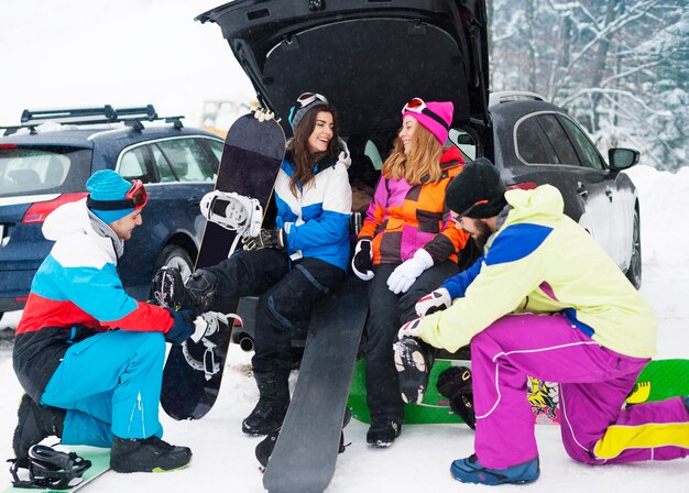 Dois casais se divertindo e praticando snowboard