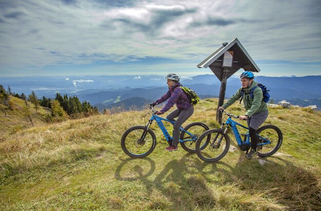 Dois ciclistas no pico de uma montanha com um belo ambiente
