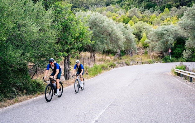 Dois ciclistas treinando em uma imagem de ciclismo de estrada de montanha com conceito saudável de espaço de cópia
