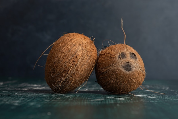 Dois cocos inteiros na mesa de mármore.