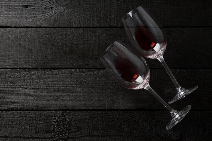 Foto grátis dois copos de vinho vermelho sobre um fundo escuro