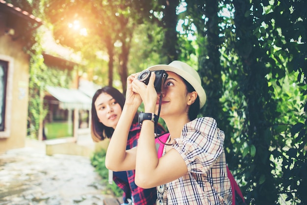 Dois da mulher que tem o bom tempo ao sentar-se na filial após andar através do urbano.