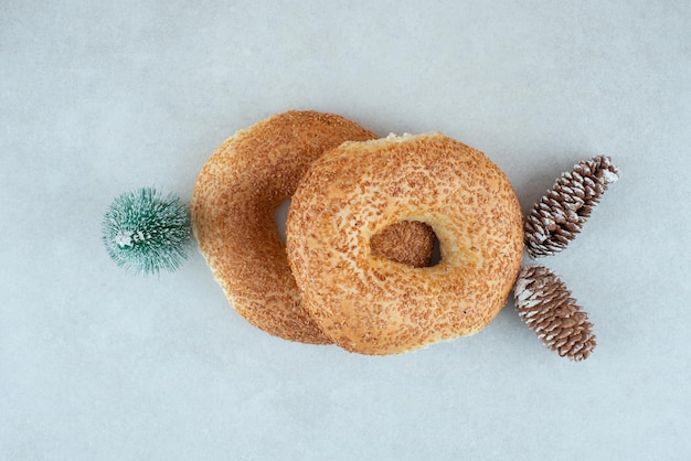 Dois deliciosos bagels com pequena árvore de natal e pinhas.