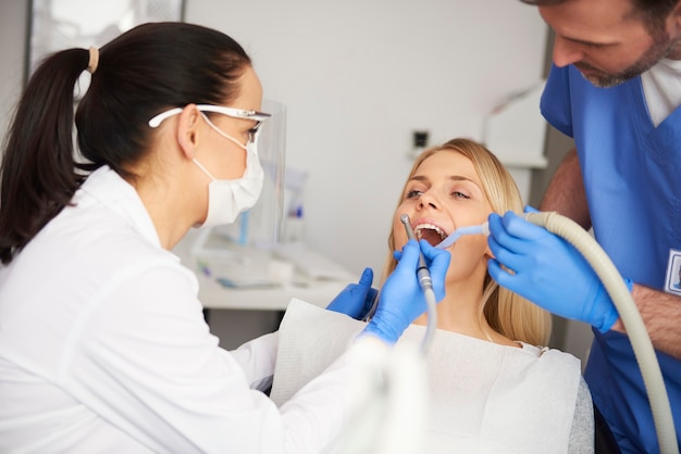 Dois dentistas fazendo seu trabalho em clínica dentária