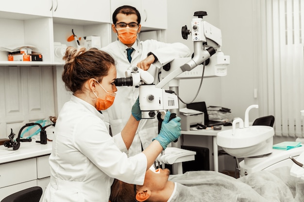 Dois dentistas tratam um paciente. uniforme profissional e equipamento de um dentista. assistência médica equipando um local de trabalho doctos. odontologia