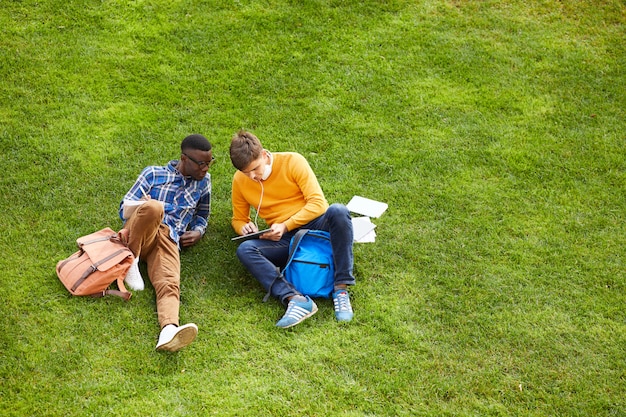 Dois estudantes relaxando na grama verde
