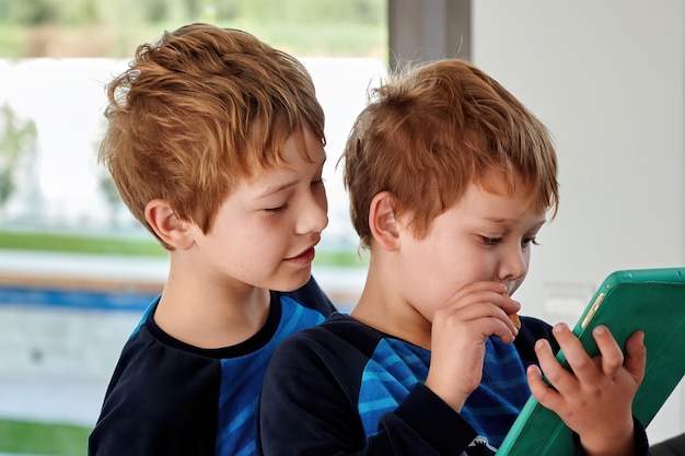 Dois irmãos ruivos jogando jogos no tablet