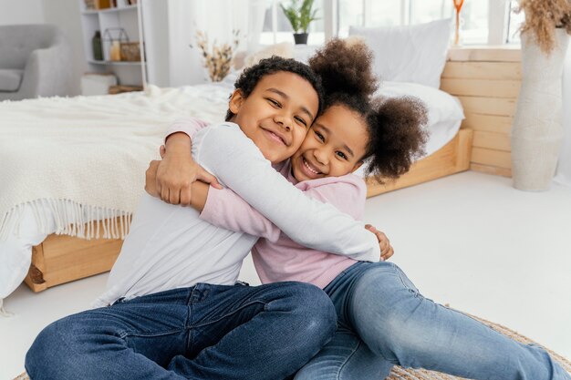 Dois irmãos se abraçando em casa