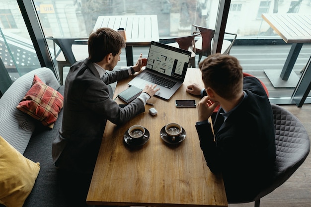 Foto grátis dois jovens empresário tendo uma reunião bem sucedida no restaurante.