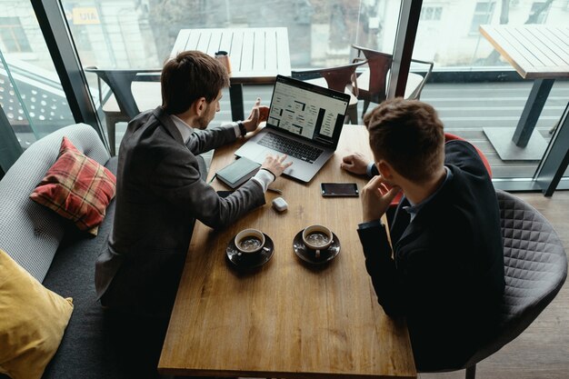 Dois jovens empresário tendo uma reunião bem sucedida no restaurante.