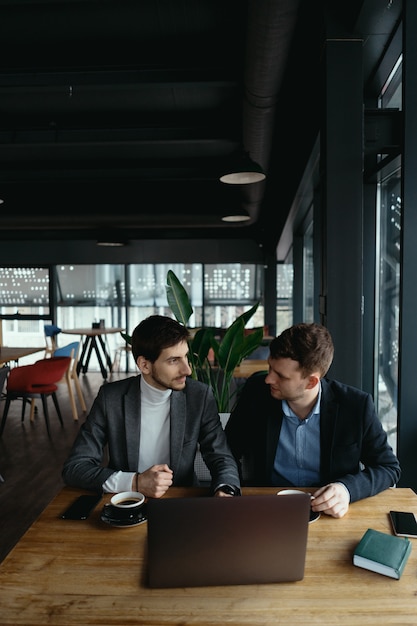 Dois jovens empresário tendo uma reunião bem sucedida no restaurante.