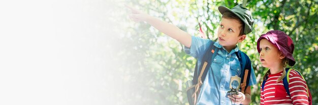 Dois lindos filhos caminhando no banner de espaço de design de floresta