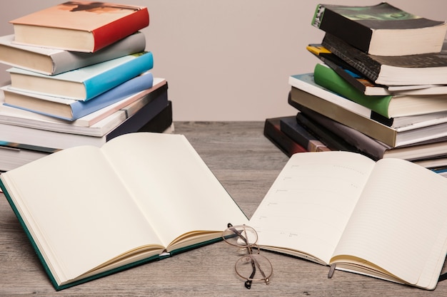 Foto grátis dois livros abertos na frente de duas pilhas de livros