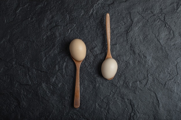 Foto grátis dois ovos de galinha frescos em colheres de pau.