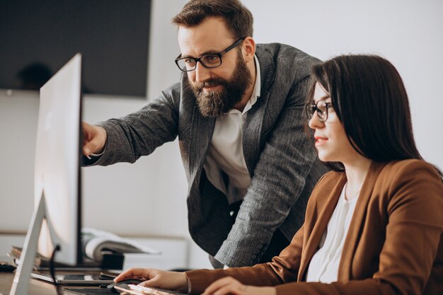 Dois parceiros de negócios trabalhando juntos no escritório no computador