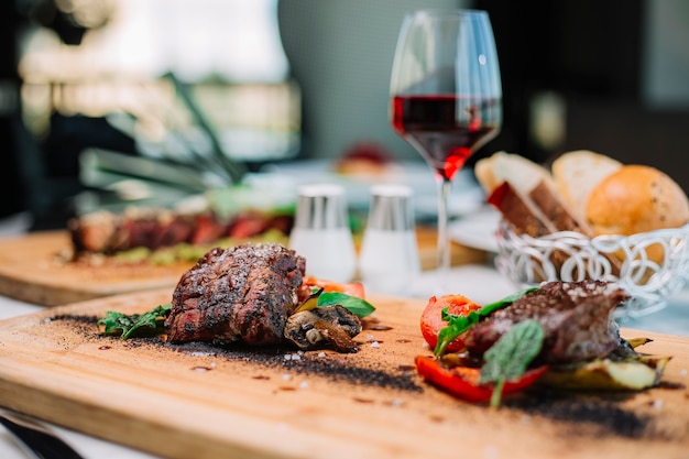 Dois pedaços de bife cozido médio, servido com cogumelos e abobrinha