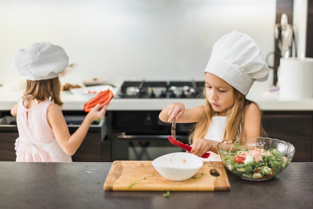 Dois, pequeno, crianças, em, chapéu cozinheiro, preparando alimento, em, cozinha