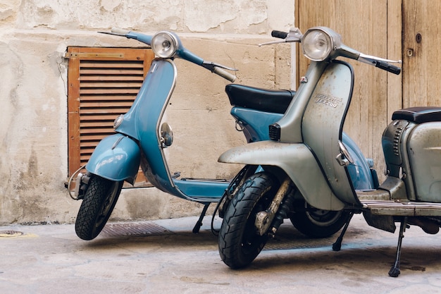 Dois scooters do vintage estacionado na rua