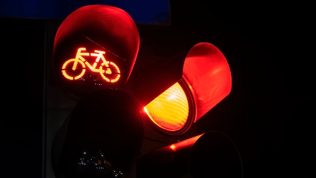 Dois semáforos vermelhos com logotipo de bicicleta em um à noite em Bucareste, Romênia