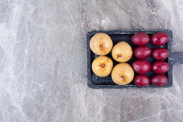 Dois tipos de frutas em conserva no quadro escuro.