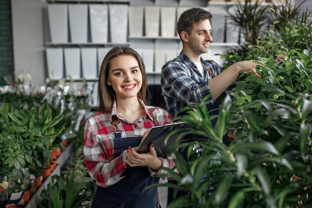 Dois trabalhadores com roupas especiais trabalhando no centro de jardinagem