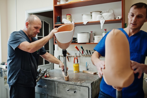 Dois trabalhadores protéticos fazendo perna protética enquanto trabalhava em laboratório